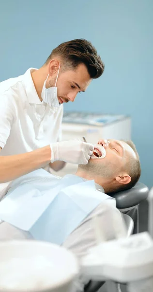 Dentista y paciente durante un tratamiento de ortodoncia — Foto de Stock