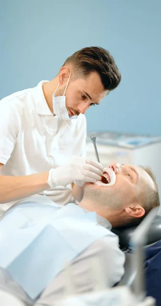 Dentista e paciente durante um tratamento ortodôntico — Fotografia de Stock