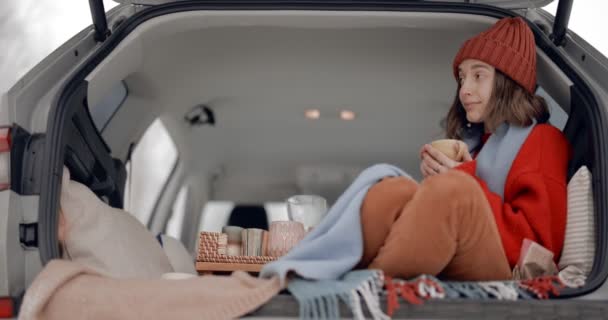 Kvinna i en bil bagageutrymme, reser under en vintersemester — Stockvideo