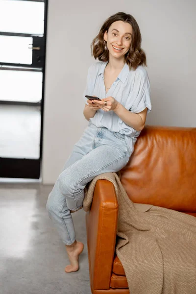 Donna che utilizza Smartphone seduto sul divano — Foto Stock