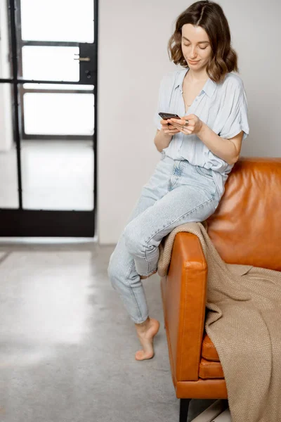 Donna che utilizza Smartphone seduto sul divano — Foto Stock