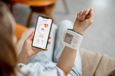 Kadın kalp atışlarını ve basıncını akıllı teknolojiyle ölçer.