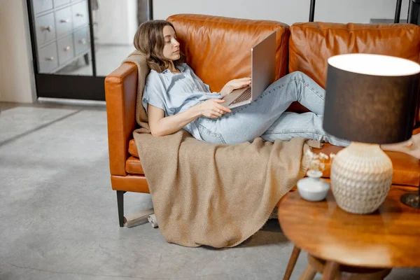 Donna che lavora con laptop da casa sul divano — Foto Stock