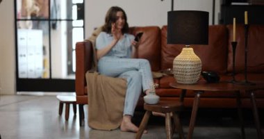 Işığı evde akıllı bir telefonla kontrol eden kadın.