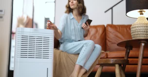 Woman with air purifier or conditioner at home — Stock Video