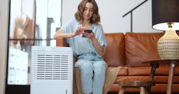 Mujer con purificador de aire o acondicionador en casa — Vídeo de stock