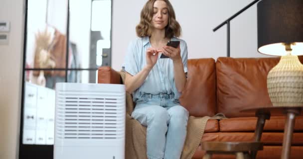 Femme avec purificateur d'air ou climatiseur à la maison — Video