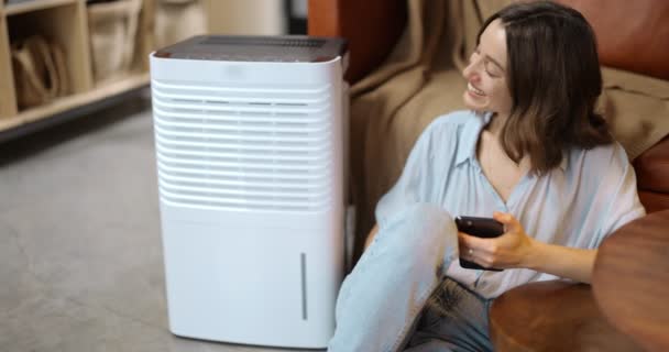 Frau mit Luftreiniger oder Klimaanlage zu Hause — Stockvideo