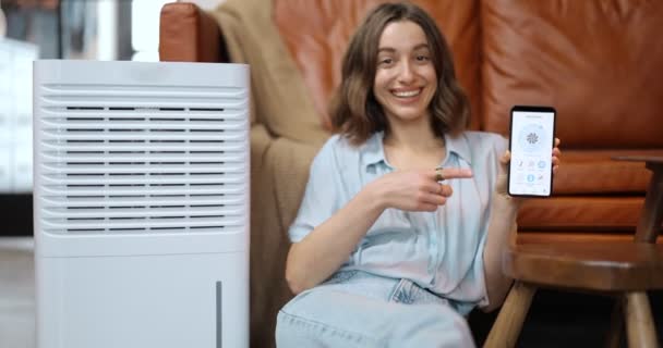 Жінка з очищувачем повітря або кондиціонером вдома — стокове відео