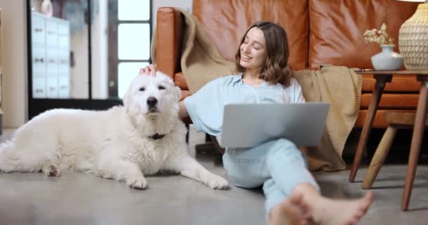 Mujer con un perro y un portátil en casa — Vídeos de Stock