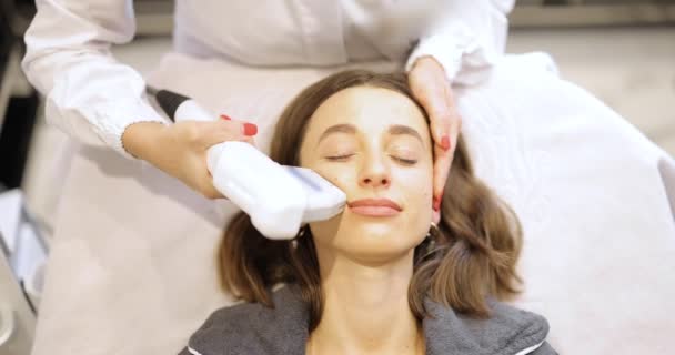 Женщина на УЗИ лица процедуры лифтинга в косметологическом салоне — стоковое видео