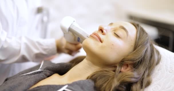 Mujer en ultrasonido procedimiento de lifting facial en salón de cosmetología — Vídeo de stock