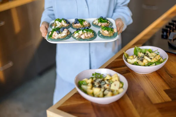 Woman hold a set of appetizer on a plate and salads — Stok fotoğraf