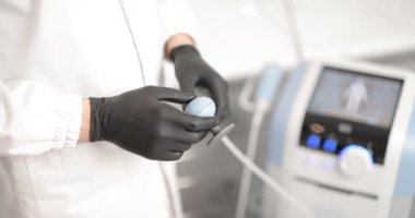 Manyetik terapi makinesi olan bir doktor.