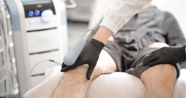 Arzt macht Magnettherapie am Knie des Mannes — Stockvideo