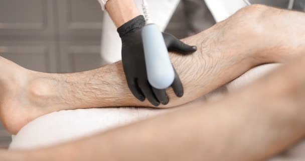 医者は男性の足で磁気療法を行う — ストック動画