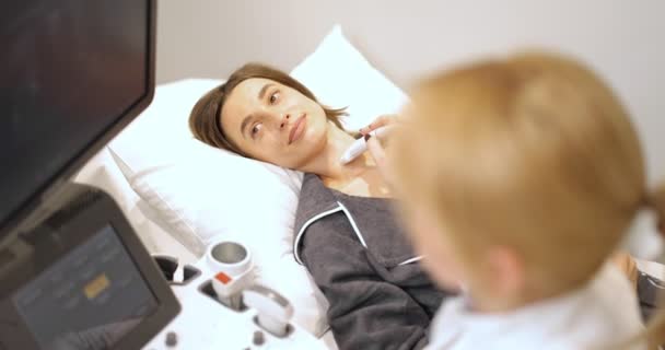Лікар вивчення щитовидної залози пацієнта з ультразвуковим скануванням у клініці — стокове відео
