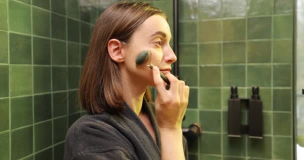 Giovane donna fa massaggio facciale con un rullo viso — Video Stock