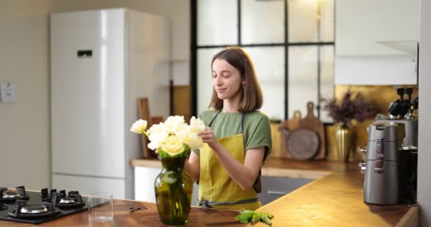Woman decorates home interior with a bouquet of fresh flowers Stock Footage