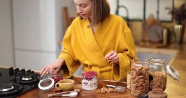 Kadın evdeki mutfakta mısır gevreği hazırlıyor.