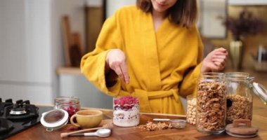 Kadın evdeki mutfakta mısır gevreği hazırlıyor.