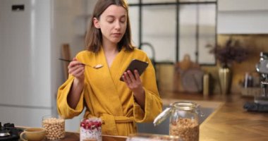 Evdeki mutfakta kahvaltı yapan bir kadın.