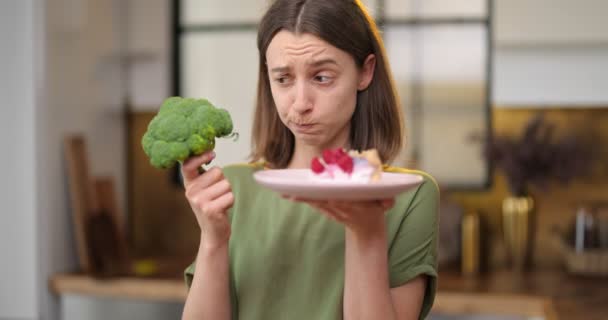 La mujer hace una elección entre comida saludable y postre dulce — Vídeo de stock