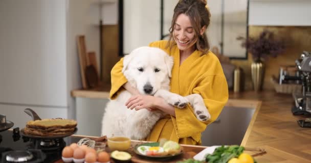 Mulher com cão na cozinha pela manhã — Vídeo de Stock