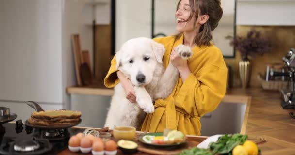 Woman with dog on the kitchen in the morning — Stock Footage Woman with dog on the kitchen in the morning Royalty Free Stock Video