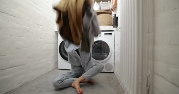 Ama de casa vomitando ropa en la lavandería — Vídeo de stock