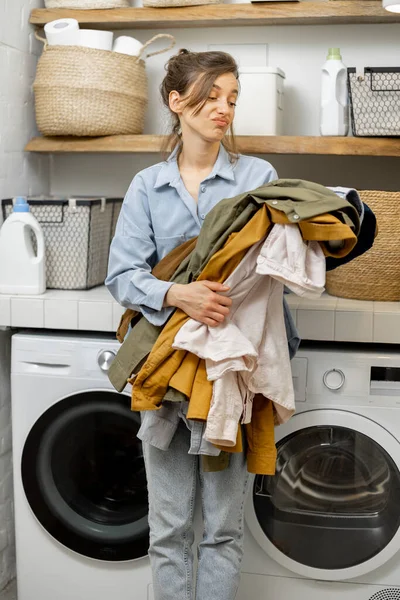 Triste femme avec des vêtements dans la terre à la maison — Photo