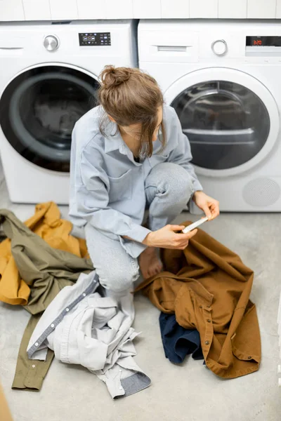 Ev hanımı çamaşırhanede kirli çamaşırları düzenler. — Stok fotoğraf