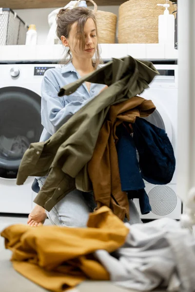 Femme au foyer trie des vêtements sales dans la blanchisserie — Photo