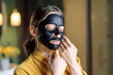 Yüzünde temizlik maskesi olan bir kadın.