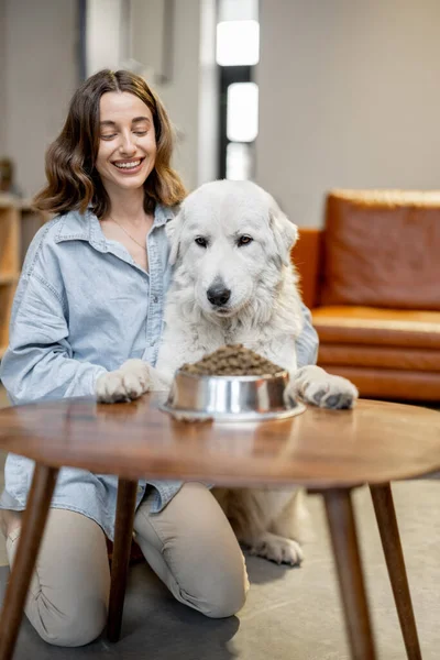 Kvinna matar en hund med torrfoder — Stockfoto