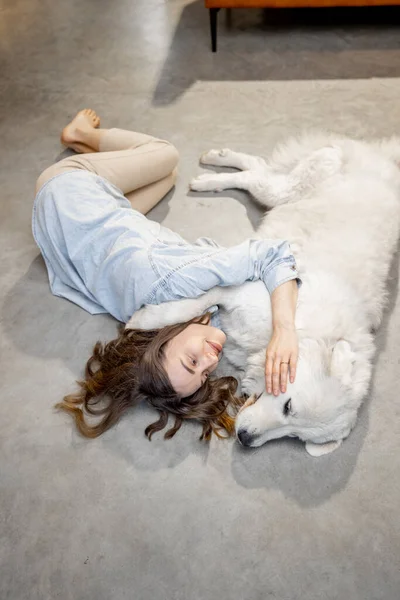 Женщина со своей собакой, лежащей вместе — стоковое фото