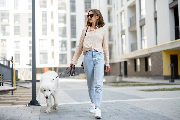 Mujer caminando con su gran perro blanco en la calle —  Fotos de Stock