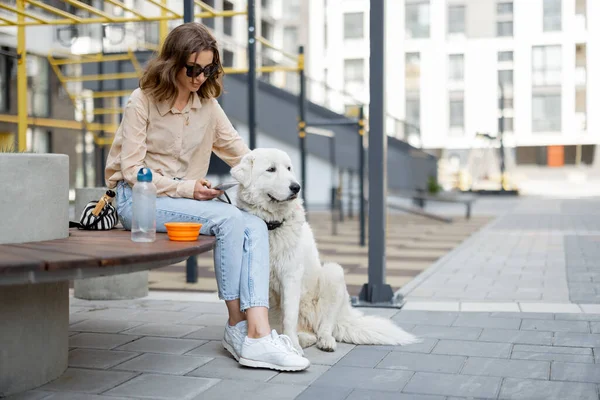 Kvinna som sitter på bänk med husdjur på gården i residenset — Stockfoto