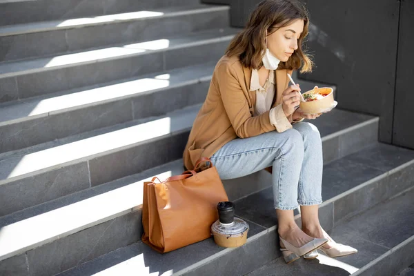 Mulher almoçar ao ar livre em escadas perto de prédio de escritórios — Fotografia de Stock