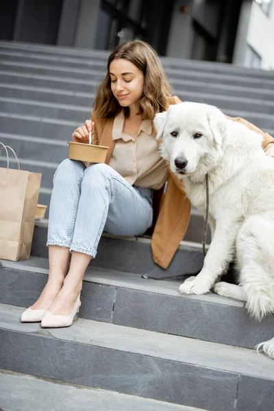 Kvinna äter lunch utomhus med hund — Stockfoto
