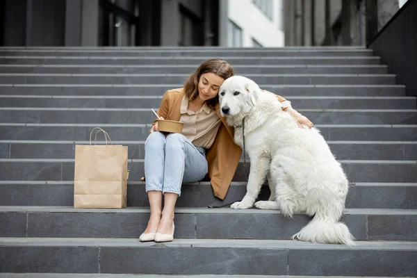 Kvinna äter lunch utomhus med hund — Stockfoto