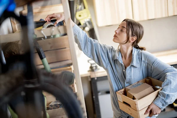 Femme à la recherche d'outils dans l'atelier — Photo