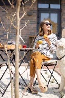 Bahçedeki masada oturan neşeli kadın..