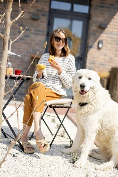 Femme joyeuse assise à une table dans le jardin. — Photo