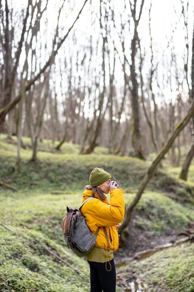 Žena v turistickém oblečení s kamerou v lese — Stock fotografie