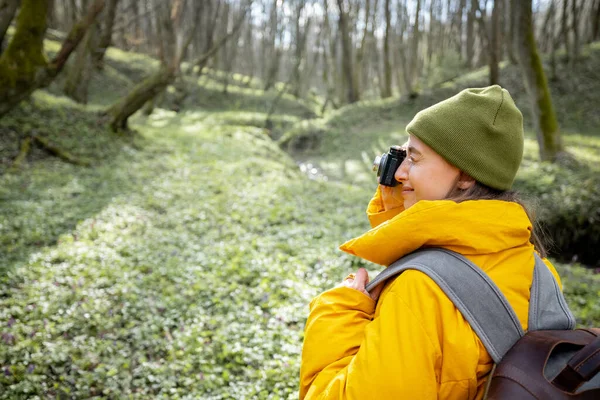 Kvinna i vandringskläder med kamera i skogen — Stockfoto