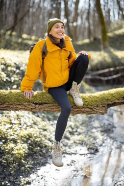 Nehrin yukarısındaki ağaçta oturan kadın.