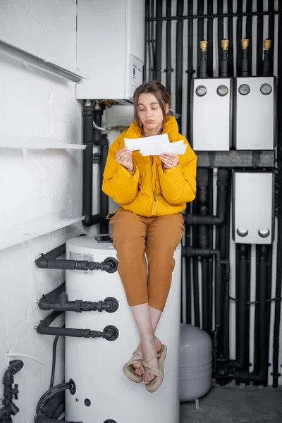 Жінка перевіряє рахунки за електрику вдома — стокове фото