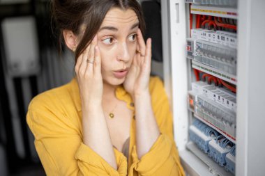 Kadın evde elektrik faturalarını kontrol ediyor.