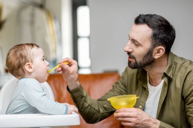 Babası bir yaşındaki oğlunu kaşıkla besliyor..